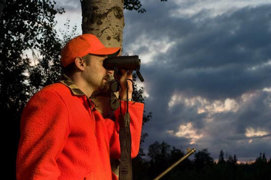 Cacciatore che osserva nel bosco alla scova di qualche ungulato