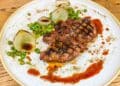 Carré di cinghiale, crema di piselli, cipolla alla brace e piselli saltati