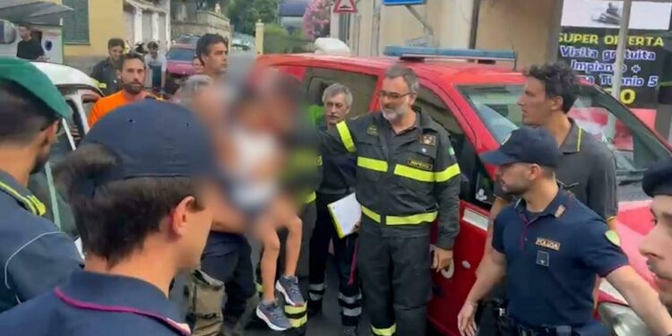 Allan Bernard Ganao, il bambino di 5 anni scomparso venerdì notte da un camping di Latte a Ventimiglia, in braccio a una delle persone che ha collaborato alle ricerche, 13 luglio 2025. ANSA