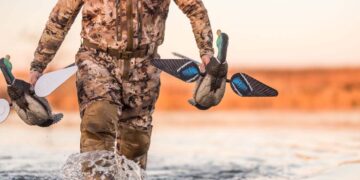 Cacciatore trasporta stampi Final Approach per anatre in laguna